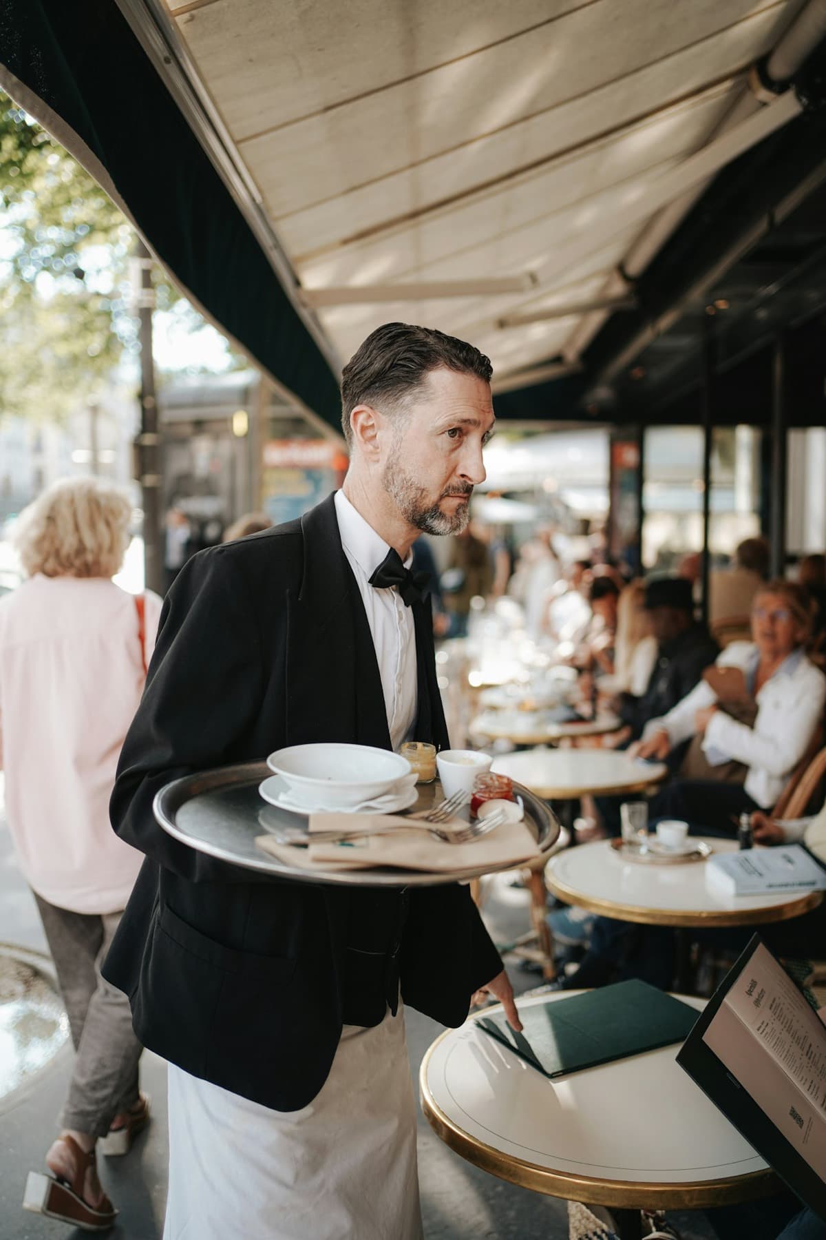 Un serveur en terrasse, plateau à la main